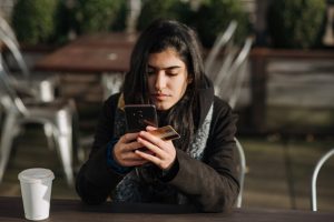 mujer sentada escribiendo en su teléfono